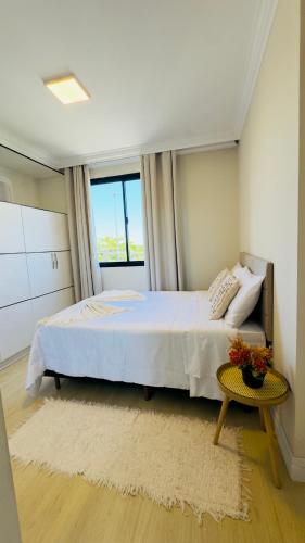 a bedroom with a large bed and a window at Apê com vista para o mar e clima animado in Vitória