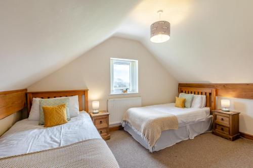 a attic bedroom with two beds and a window at 7 Bed in Caerwys oc-58357 in Caerwys