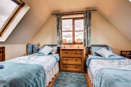 two beds in a attic room with a window at 2 Bed in Welshpool oc-75703 in Meifod