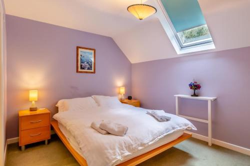 a bedroom with a large white bed with a skylight at 2 Bed in Charmouth oc-wy395 in Charmouth
