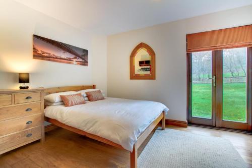 a bedroom with a bed and a dresser and a window at 3 Bed in Bala oc-bow162 in Bala