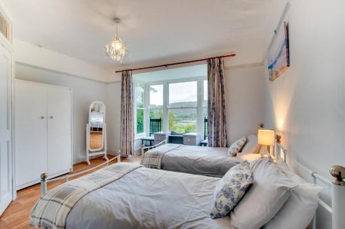 two beds in a bedroom with a window at 6 Bed in Dolgellau oc-wah675 in Arthog