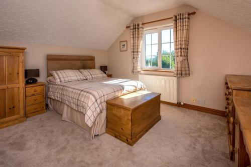 a bedroom with a bed and a dresser and a window at 5 Bed in Bryncroes oc-llecyn in Pwllheli