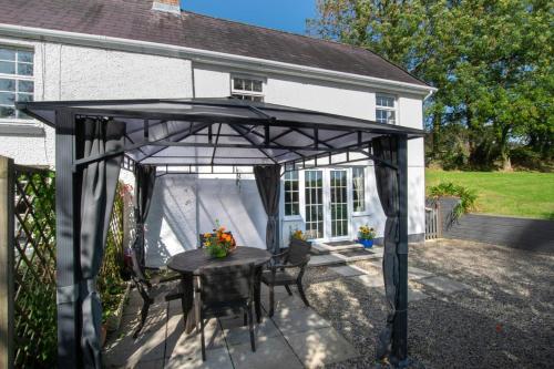 a black pergola with a table in front of a house at 2 Bed in Felindre oc-hh39 in Felindre