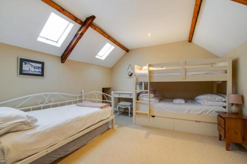 two bunk beds in a attic bedroom with skylights at 4 Bed in Gower oc-hh701 in Port-Eynon