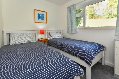 two beds in a room with a window at 3 Bed in Pwllheli oc-16glyn in Llanbedrog