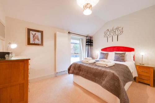 a bedroom with a large bed with a red headboard at 1 Bed in Woodbridge oc-stabu in Ufford