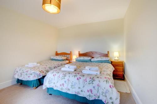 two twin beds in a room with white walls at 2 Bed in Barmouth oc-wah698 in Talybont