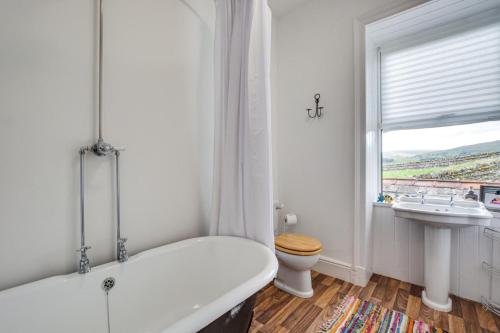 a white bathroom with a tub and a sink at 3 Bed in Hawes oc-ds959 in Hawes