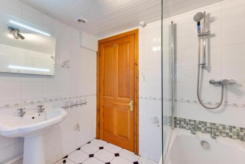 a bathroom with a sink and a tub and a shower at 3 Bed in Benllech oc-24195 in Benllech