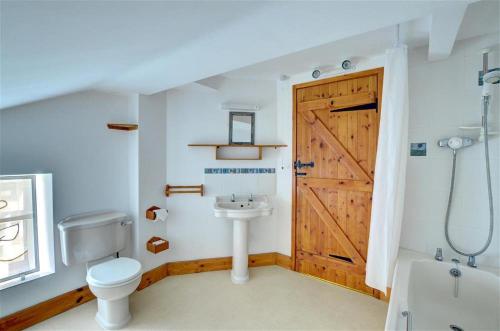 a bathroom with a wooden door and a toilet and a sink at 4 Bed in Presteigne oc-wak235 in Norton