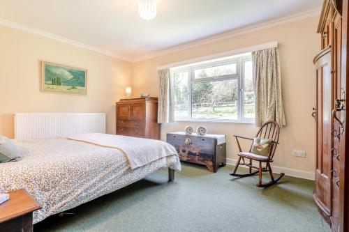 a bedroom with a bed and a chair and a window at 4 Bed in Godalming oc-b30296 in Hook