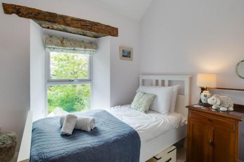 a bedroom with a bed and a window at 5 Bed in Gower oc-hh101 in Port-Eynon