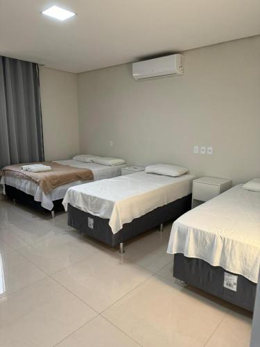 a room with three beds in a room at Atlanta Hotel in Ibotirama