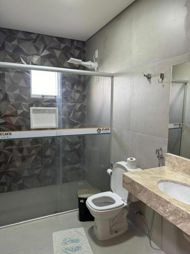 a bathroom with a toilet and a sink and a shower at Atlanta Hotel in Ibotirama