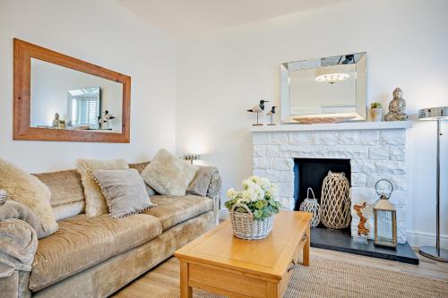 a living room with a couch and a fireplace at 6 Bed in Pwllheli oc-argrai in Abersoch
