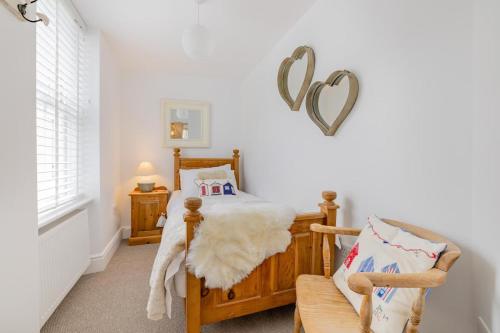 a room with a bed and a chair with a heart on the wall at 6 Bed in Pwllheli oc-argrai in Abersoch