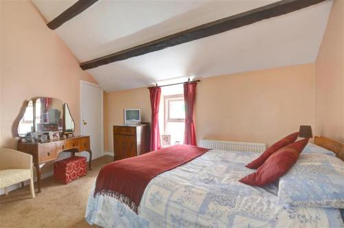 a bedroom with a large bed with red pillows at 2 Bed in Caernarfon oc-wag359 in Caernarfon