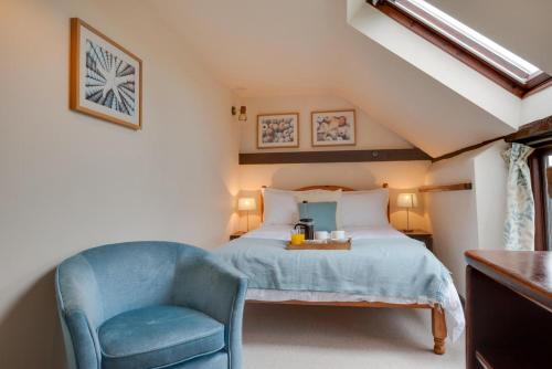 a bedroom with a bed and a blue chair at 3 Bed in Binham oc-2235 in Binham
