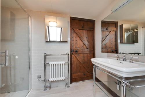 a bathroom with a sink and a shower and a mirror at 3 Bed in Binham oc-2235 in Binham