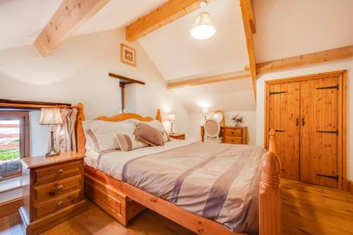 a bedroom with a wooden bed and a window at 3 Bed in Gower oc-hh407 in Llanmadoc