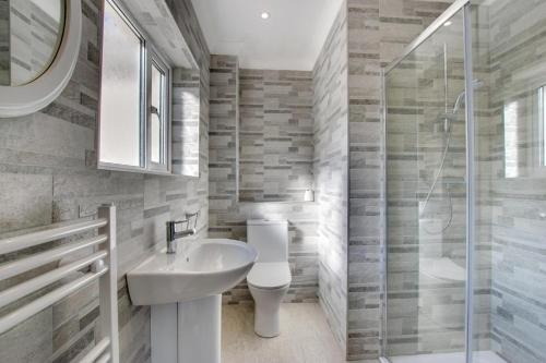 a bathroom with a sink and a toilet and a shower at 4 Bed in Swansea oc-hh642 in Oystermouth