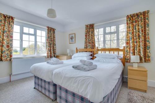 a bedroom with two beds and two windows at 4 Bed in Harmans Cross oc-wy278 in Corfe Castle