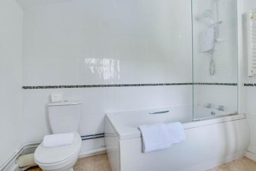 a white bathroom with a toilet and a shower at 4 Bed in Harmans Cross oc-wy278 in Corfe Castle