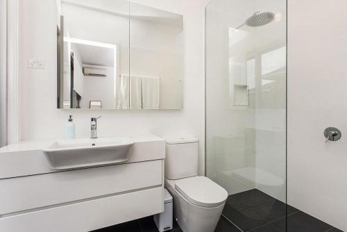 a bathroom with a toilet and a sink and a shower at Stonecutters 2 in Byron Bay