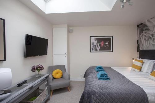 a bedroom with a bed and a couch and a tv at 2 Bed in Bath oc-bhr32 in Bath