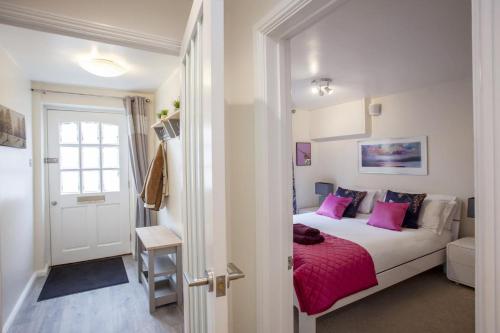 a bedroom with a bed with pink pillows at 2 Bed in Bath oc-bhr32 in Bath