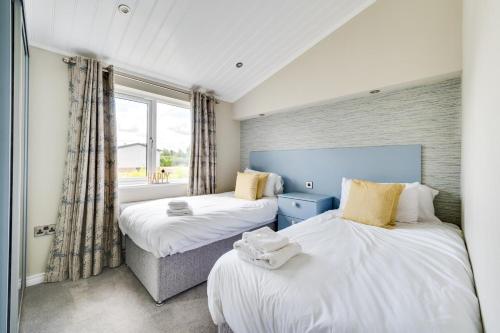 two beds in a room with a window at 3 Bed in Burnham Market oc-2333 in Burnham Market