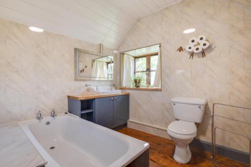 a bathroom with a tub and a toilet and a sink at 3 Bed in Dolgellau oc-wah569 in Llanfachreth