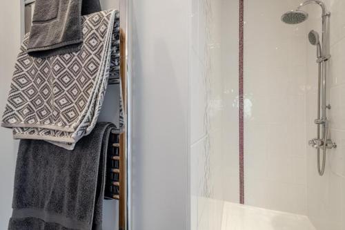 a bathroom with a shower and towels on a rack at 3 Bed in Wood Dalling oc-caba in Wood Dalling