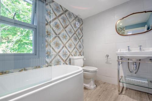 a bathroom with a tub and a toilet and a sink at 2 Bed in Beaumaris oc-wai218 in Beaumaris