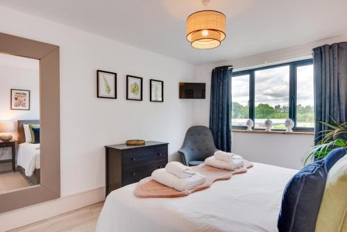 a bedroom with a bed and a mirror and a chair at 5 Bed in Briston oc-2305 in Briston