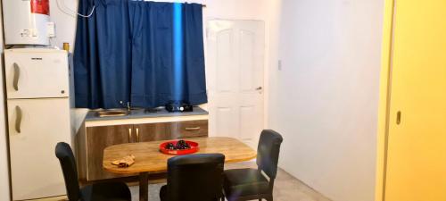 a small kitchen with a table and a blue curtain at Tres Hermanos in Trinidad