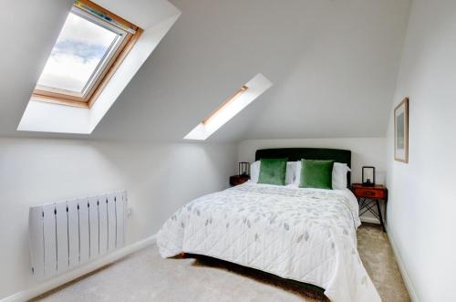 a bedroom with white walls and a bed with green pillows at 2 Bed in Newton oc-swro in Sudbury