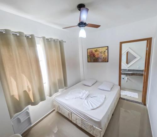 a bedroom with a bed and a ceiling fan at Hotel Santo Afonso in Aparecida