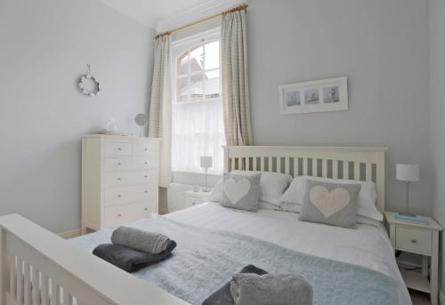 a bedroom with a white bed with two pillows at 2 Bed in Southwold oc-che in Southwold