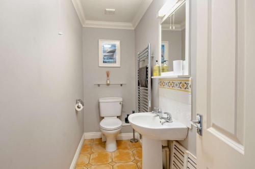 a bathroom with a white toilet and a sink at 4 Bed in Southwold oc-hsumme in Reydon