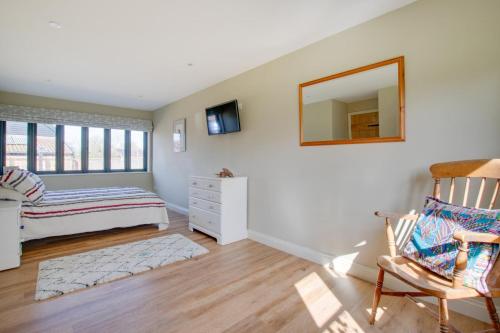 a bedroom with a bed and a mirror and a chair at 2 Bed in Weybread oc-tclwey in Needham