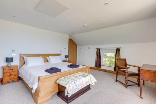 a bedroom with a wooden bed and a desk and a desk at 6 Bed in Barmouth oc-bow245 in Fairbourne
