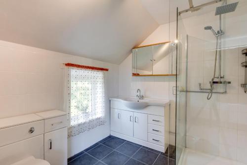 a bathroom with a sink and a toilet and a shower at 6 Bed in Barmouth oc-bow245 in Fairbourne
