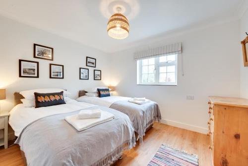 two beds in a room with white walls and a window at 2 Bed in Walberswick oc-5mart in Walberswick