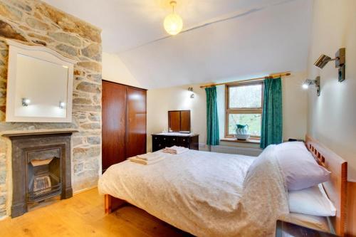 a bedroom with a large bed and a fireplace at 3 Bed in Dolgellau oc-wah464 in Llanfachreth