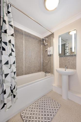 a bathroom with a tub and a sink and a shower at 3 Bed in Chedgrave oc-2252 in Chedgrave