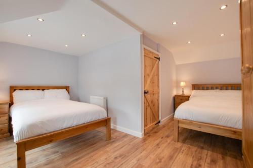 two beds in a room with white walls and wooden floors at 2 Bed in Tregaron oc-bow289 in Tregaron