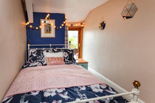 a bedroom with a bed with a blue wall at 2 Bed in Nefyn oc-tynixs in Nefyn