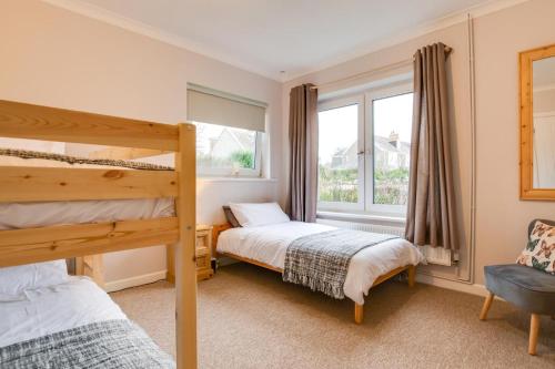 a bedroom with two bunk beds and a window at 2 Bed in Port Eynon oc-hh2104 in Port-Eynon
